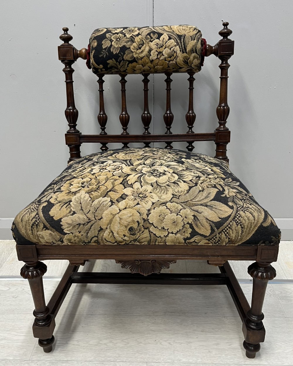 A Victorian low-seated prie-dieu prayer chair featuring turned wooden legs, a spindle back gallery, and black and gold floral tapestry fabric. View III
