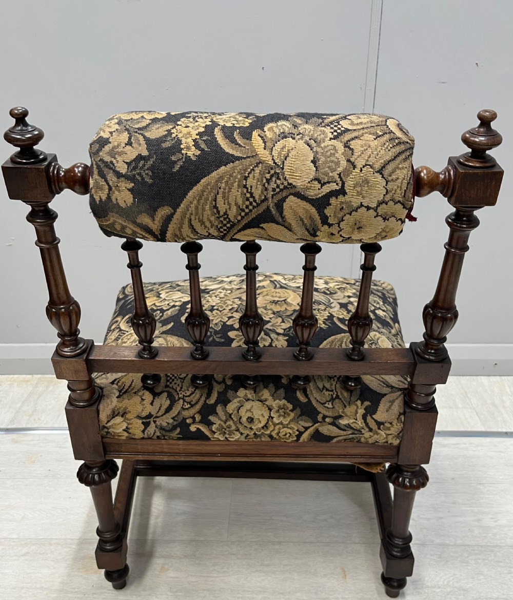 A Victorian low-seated prie-dieu prayer chair featuring turned wooden legs, a spindle back gallery, and black and gold floral tapestry fabric. View IV