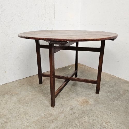 fig 1. An antique dark oak French folding vineyard table with a circular planked tilt top and a wooden cross-trestle base.
