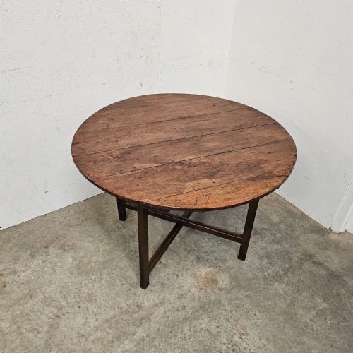 fig 2. An antique dark oak French folding vineyard table with a circular planked tilt top and a wooden cross-trestle base.