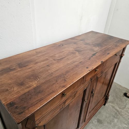 fig 1. A tall cherrywood Directoire buffet featuring three drawers above two large panelled cupboard doors with brass knobs and fluted pilasters.