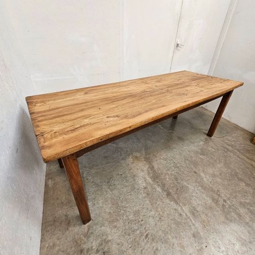 fig 1. A French rustic elm farmhouse dining table featuring a two-plank top, a pull-out side slide, and square tapered legs.