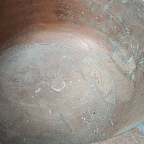 fig 1. A massive antique French copper cheese vat with a reinforced rim, showing an oxidised exterior with verdigris green highlights.