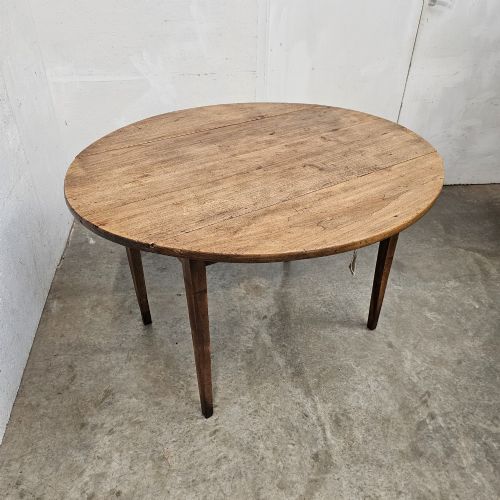 fig 2. An antique wooden French drop-leaf table with semi-circular side leaves folded down and four tapered wooden legs.