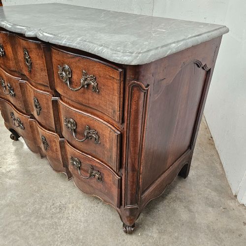 fig 2. An 18th-century French provincial walnut commode with a shaped grey marble top, serpentine drawer fronts, bronze handles, and short cabriole legs.