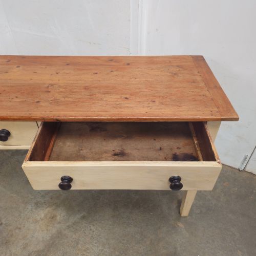 fig 1. A nineteenth-century English painted pine dairy table with a natural timber top, a cream painted base, double drawers, and dark turned wooden knobs.