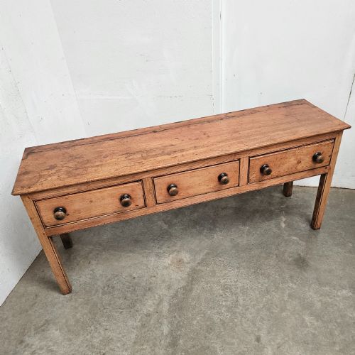 fig 1. An English country pine and elm dresser base featuring a planked top, three frieze drawers with turned knobs, and four square tapered legs.