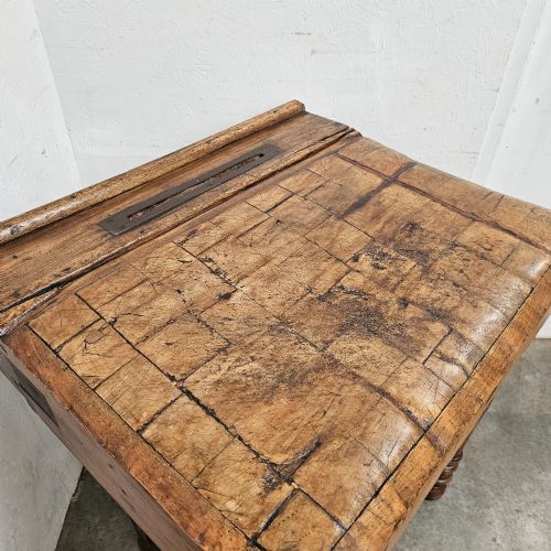 fig 1. A French beechwood butchers block featuring a thick end-grain top with metal corner brackets, a single drawer with a cup handle, a lower shelf, and turned legs.