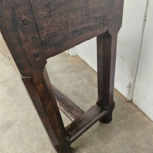fig 2. An antique dark fruitwood console table featuring a single central drawer, straight legs, and an H-stretcher base.