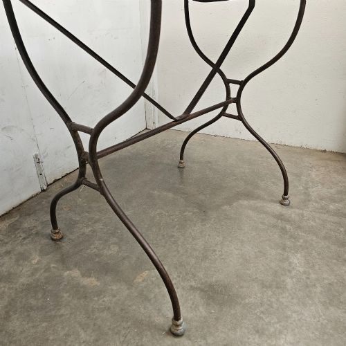 fig 2. A rectangular white veined marble top resting on a dark wrought iron base with curved legs and cross-bracing.