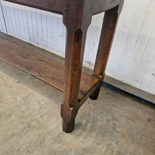 fig 2. A long, narrow dark oak French serving table featuring a plank top, square legs, and a full-length lower pot shelf.
