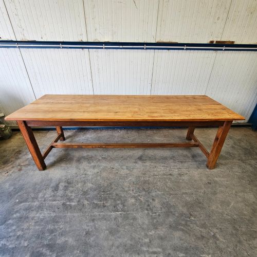 fig 1. A long French country dining table crafted from beech and elm timber with a plank top and an H-stretcher base.