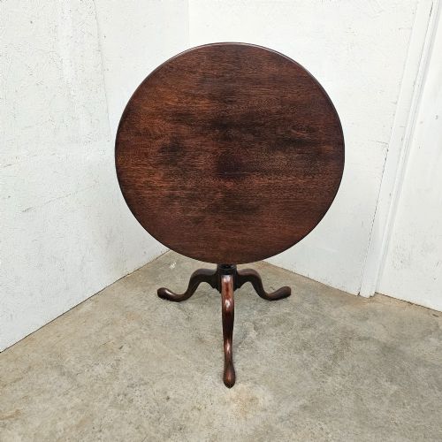 fig 2. A Georgian dark mahogany wine table featuring a circular tilt-top surface supported by a turned baluster column and three cabriole tripod legs.