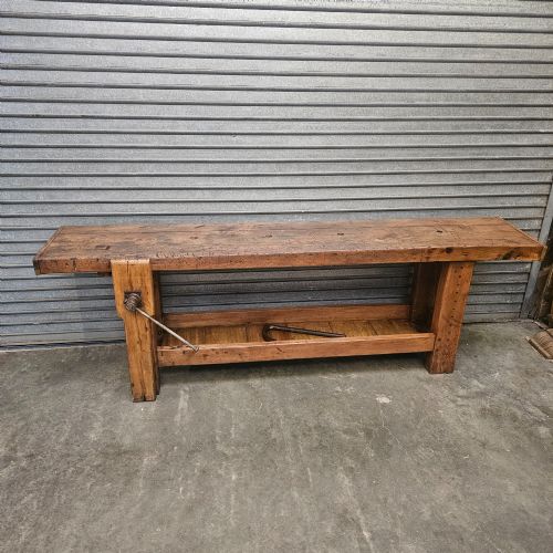 fig 2. A long, heavy French oak workbench with an integrated wooden vice, lower storage shelf, and aged iron hardware.