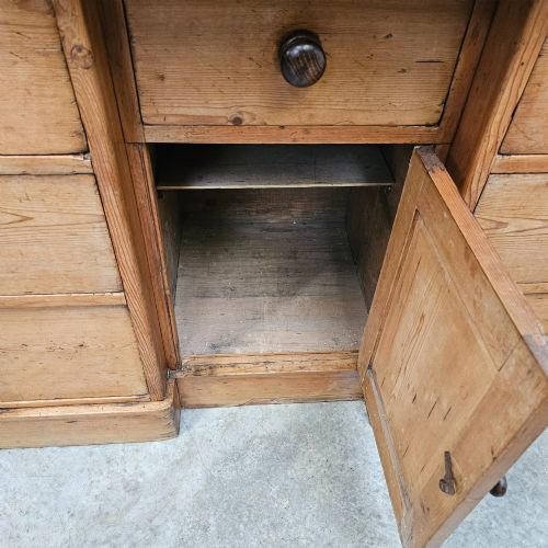 fig 1. A 19th-century English pine dresser featuring a three-tier open rack above a base unit with six drawers and a central cupboard door.