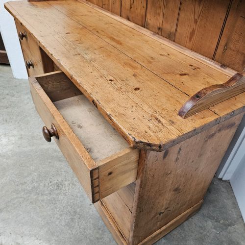 fig 2. A 19th-century English pine dresser featuring a three-tier open rack above a base unit with six drawers and a central cupboard door.