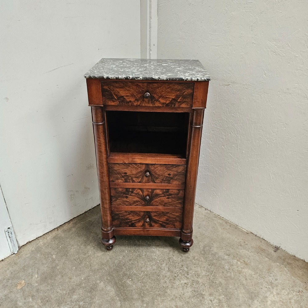 A French 19th-century figured walnut nightstand with a grey variegated marble top, featuring an open shelf above three lower drawers.