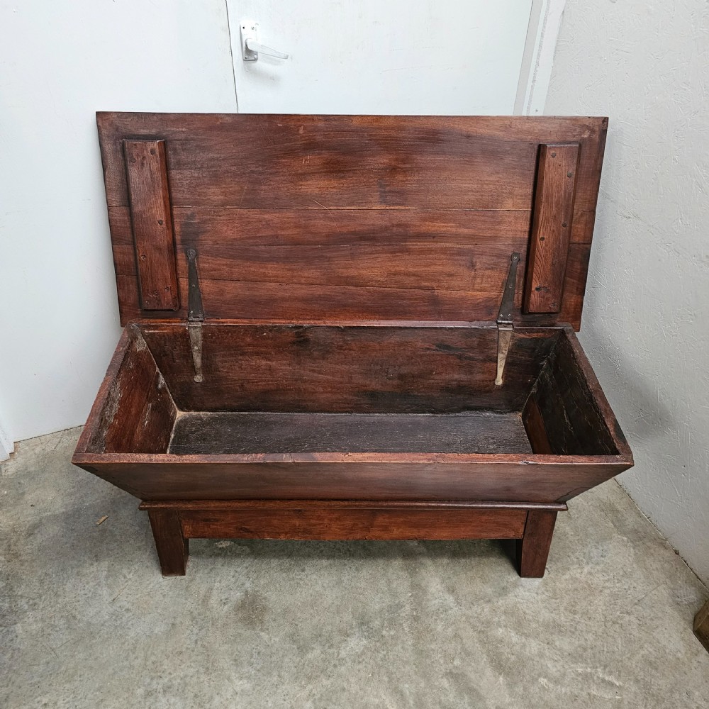 A French provincial warm brown walnut dough box featuring tapered sides, a flat top lid, and a low timber base. View III