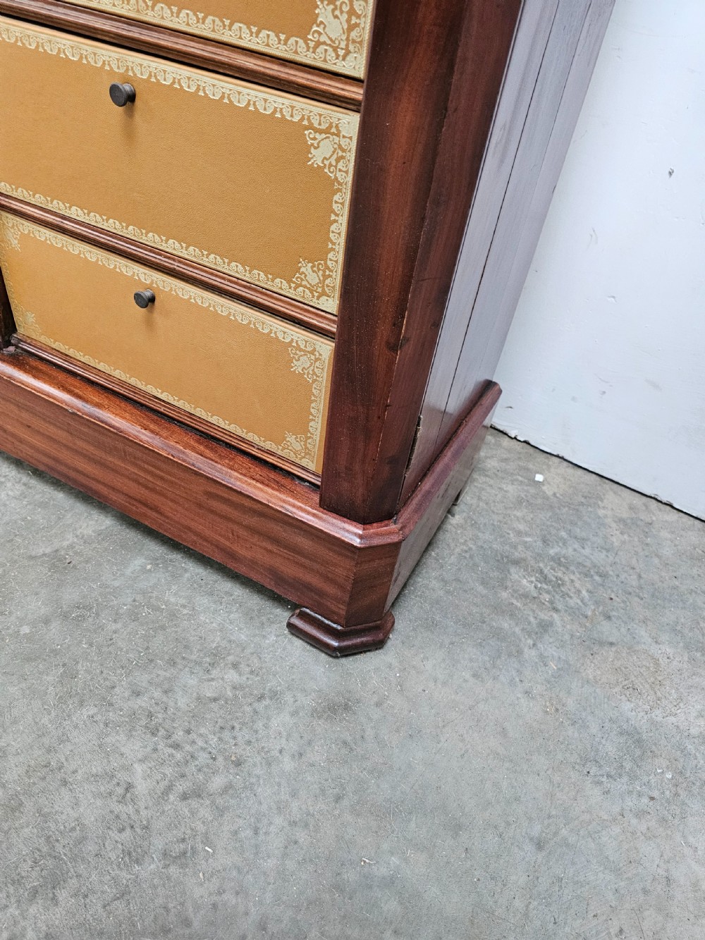 A tall French mahogany cartonnier cabinet with two vertical columns of drop-front drawers featuring gilt-tooled tan leather fronts. View IV