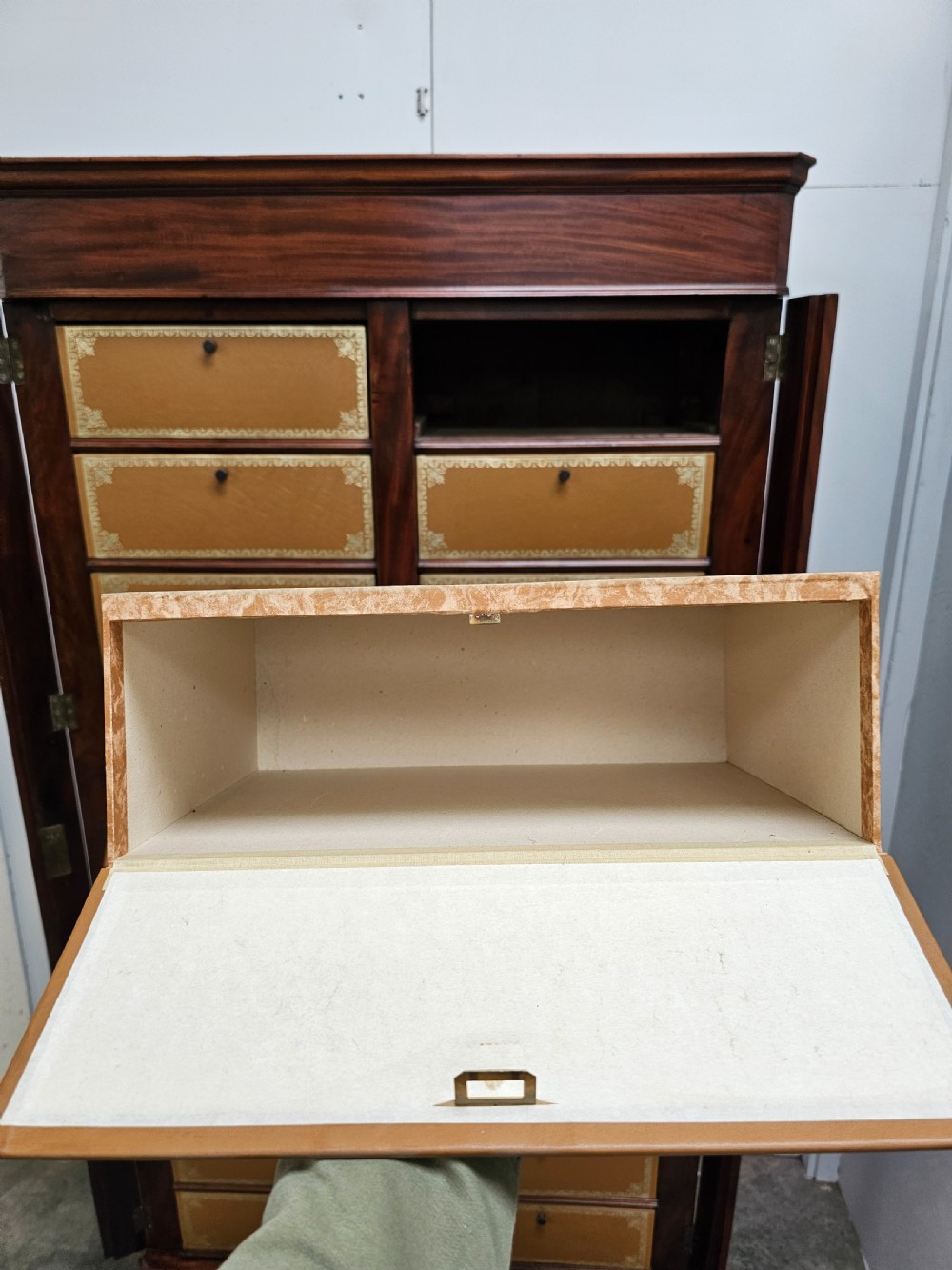 A tall French mahogany cartonnier cabinet with two vertical columns of drop-front drawers featuring gilt-tooled tan leather fronts. View VIII