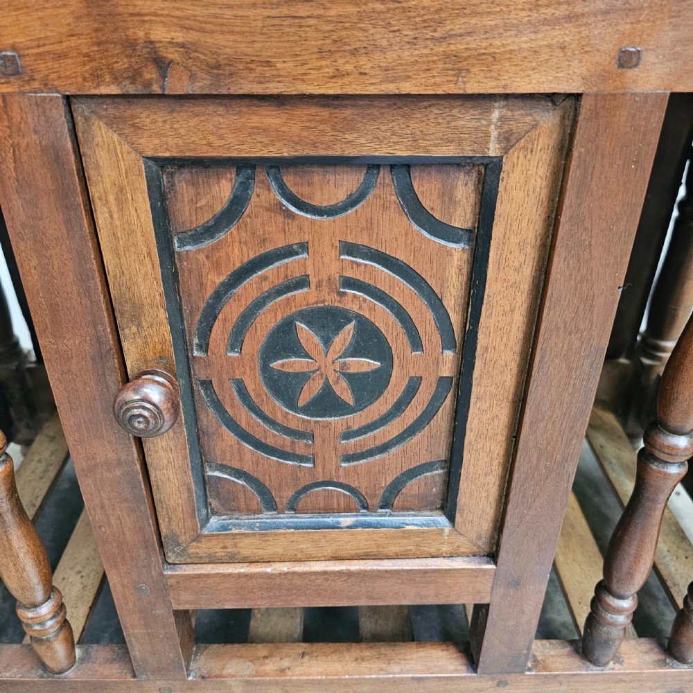 A 19th-century French provincial carved walnut panetiere featuring turned spindle balusters, a slatted base, and a central cupboard door carved with a geometric star motif. View IV