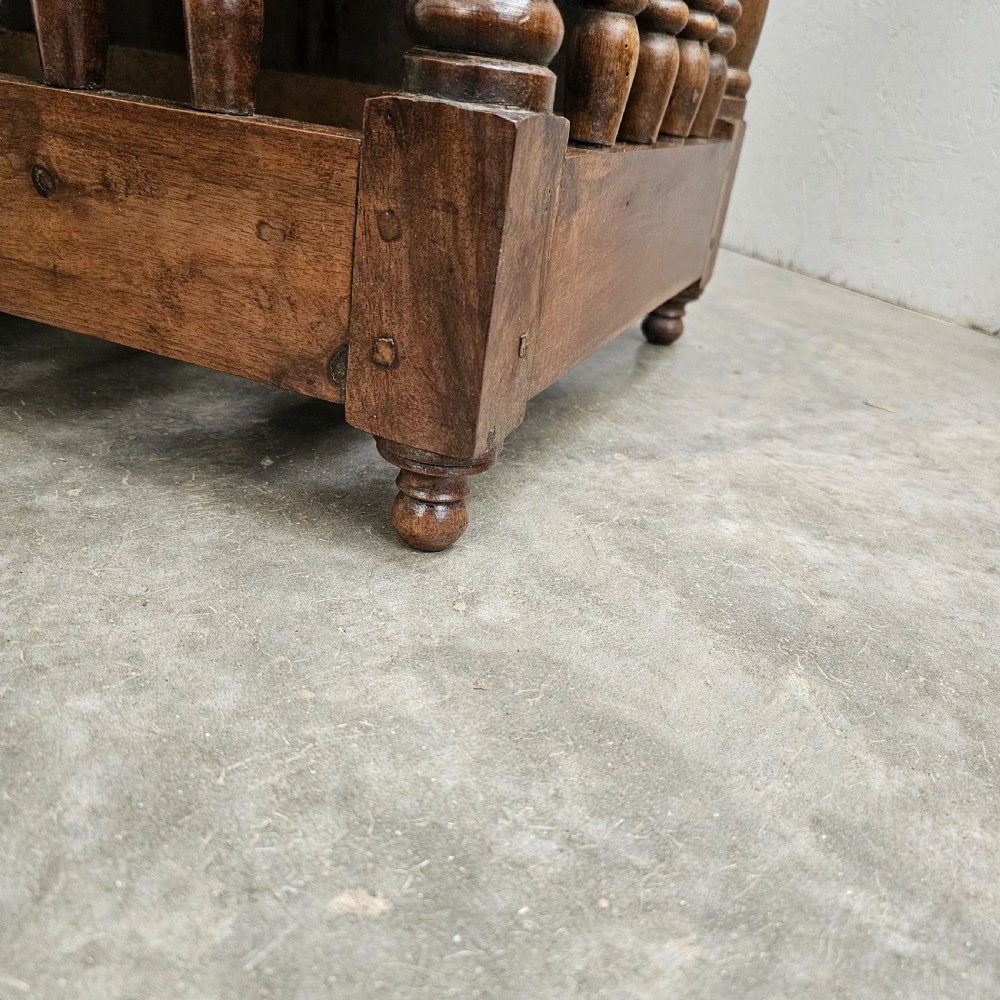 A 19th-century French provincial carved walnut panetiere featuring turned spindle balusters, a slatted base, and a central cupboard door carved with a geometric star motif. View VIII