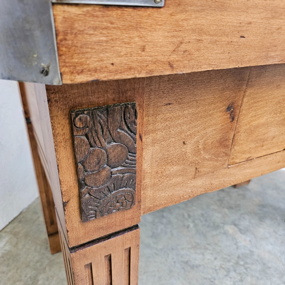 An antique French beech butchers block featuring a dished top surface, metal corner brackets, a single drawer, and carved square legs. View V