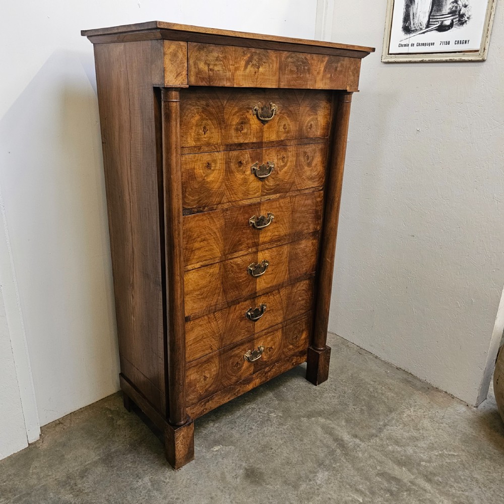 A tall 19th-century French Empire chest of drawers featuring bookmatched walnut grain veneer, flank column pilasters, and six stacked drawers with brass bail handles. View III