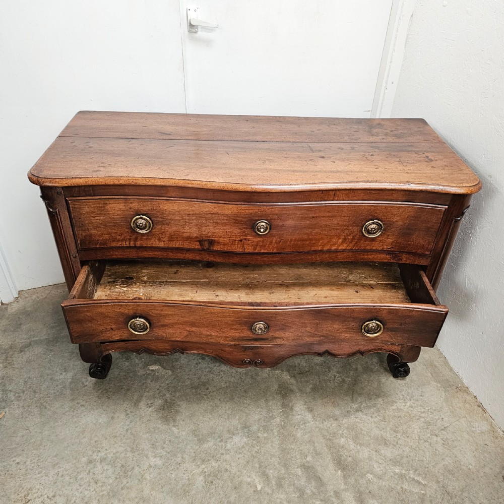 A nineteenth-century French serpentine wood commode featuring three drawers with brass ring handles and carved cabriole legs. View VII