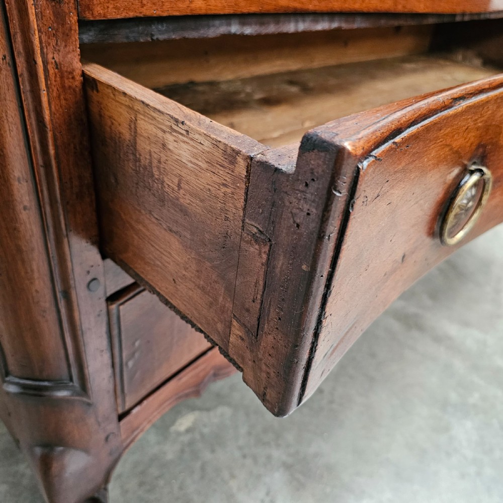 A nineteenth-century French serpentine wood commode featuring three drawers with brass ring handles and carved cabriole legs. View VIII