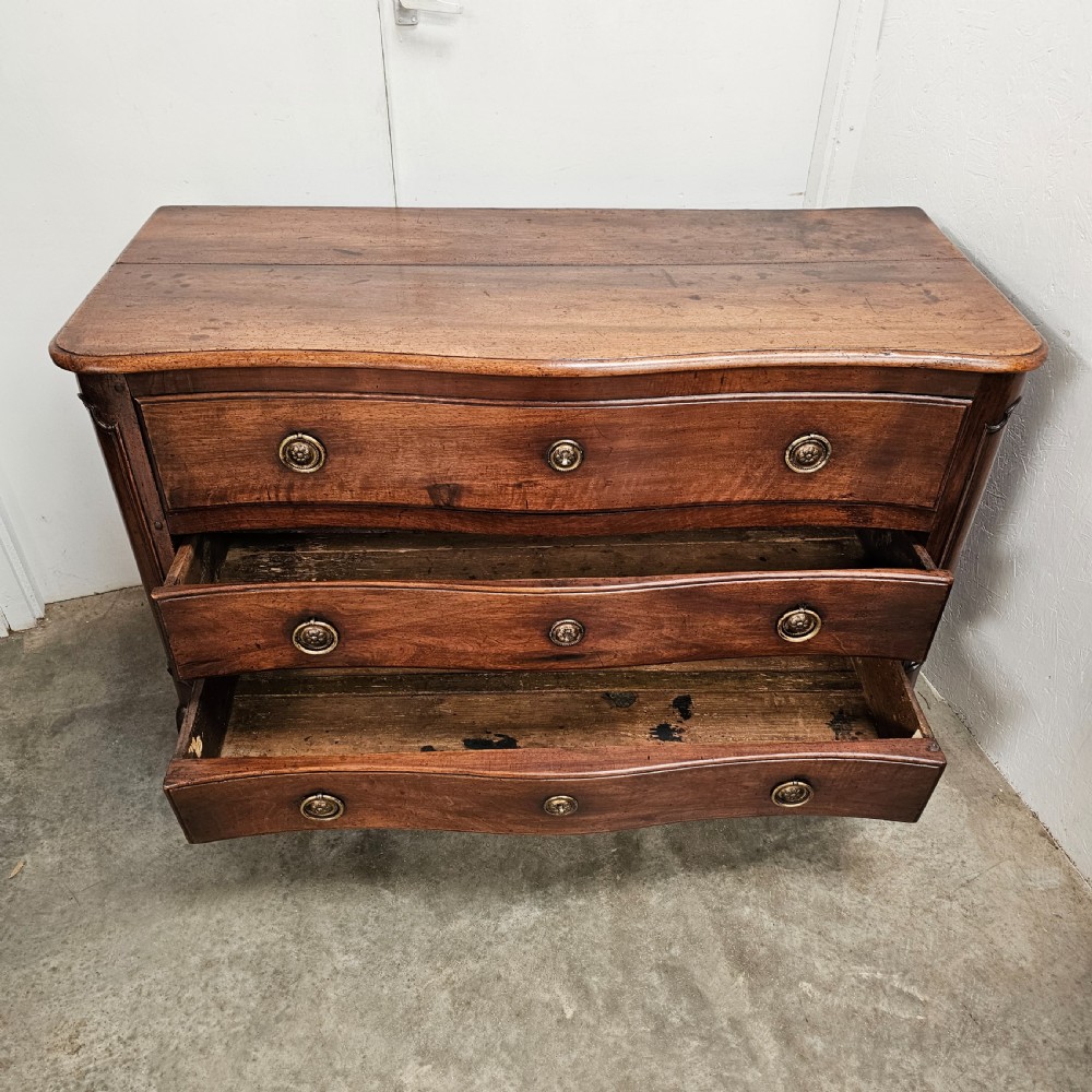 A nineteenth-century French serpentine wood commode featuring three drawers with brass ring handles and carved cabriole legs. View IX