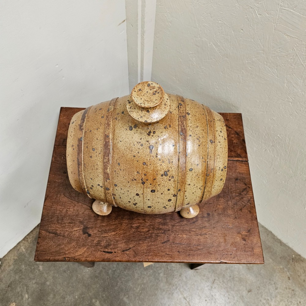 A horizontal ceramic barrel-shaped stoneware vinegar vessel with a speckled salt glaze finish, raised top opening, simulated wooden hoops, and integrated stoneware feet. View II