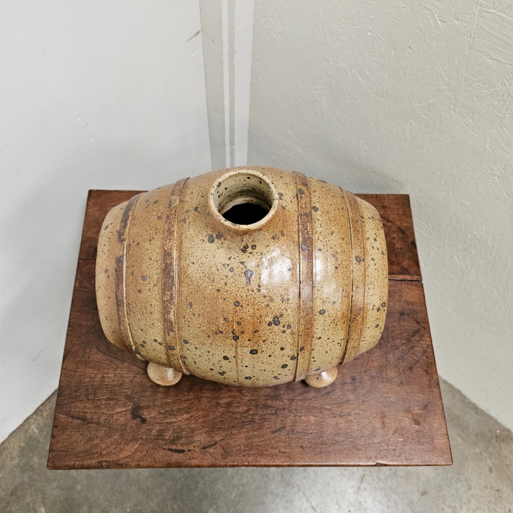 A horizontal ceramic barrel-shaped stoneware vinegar vessel with a speckled salt glaze finish, raised top opening, simulated wooden hoops, and integrated stoneware feet. View III