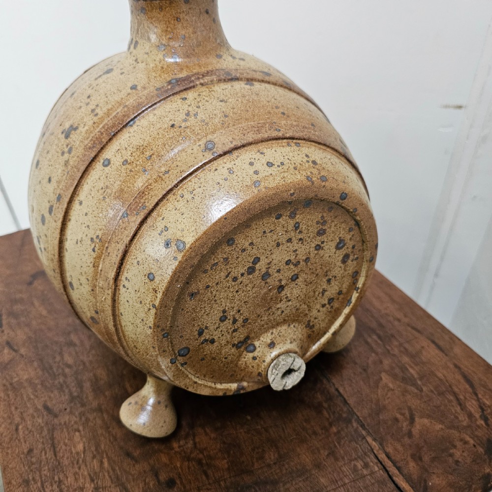 A horizontal ceramic barrel-shaped stoneware vinegar vessel with a speckled salt glaze finish, raised top opening, simulated wooden hoops, and integrated stoneware feet. View IV