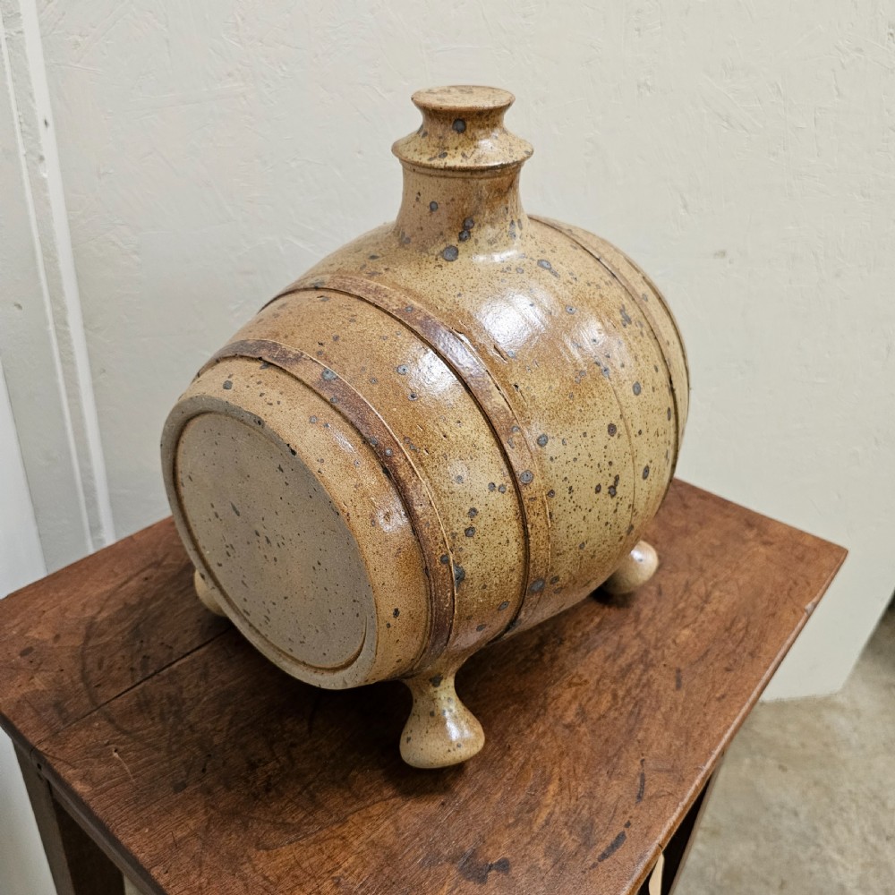 A horizontal ceramic barrel-shaped stoneware vinegar vessel with a speckled salt glaze finish, raised top opening, simulated wooden hoops, and integrated stoneware feet. View V