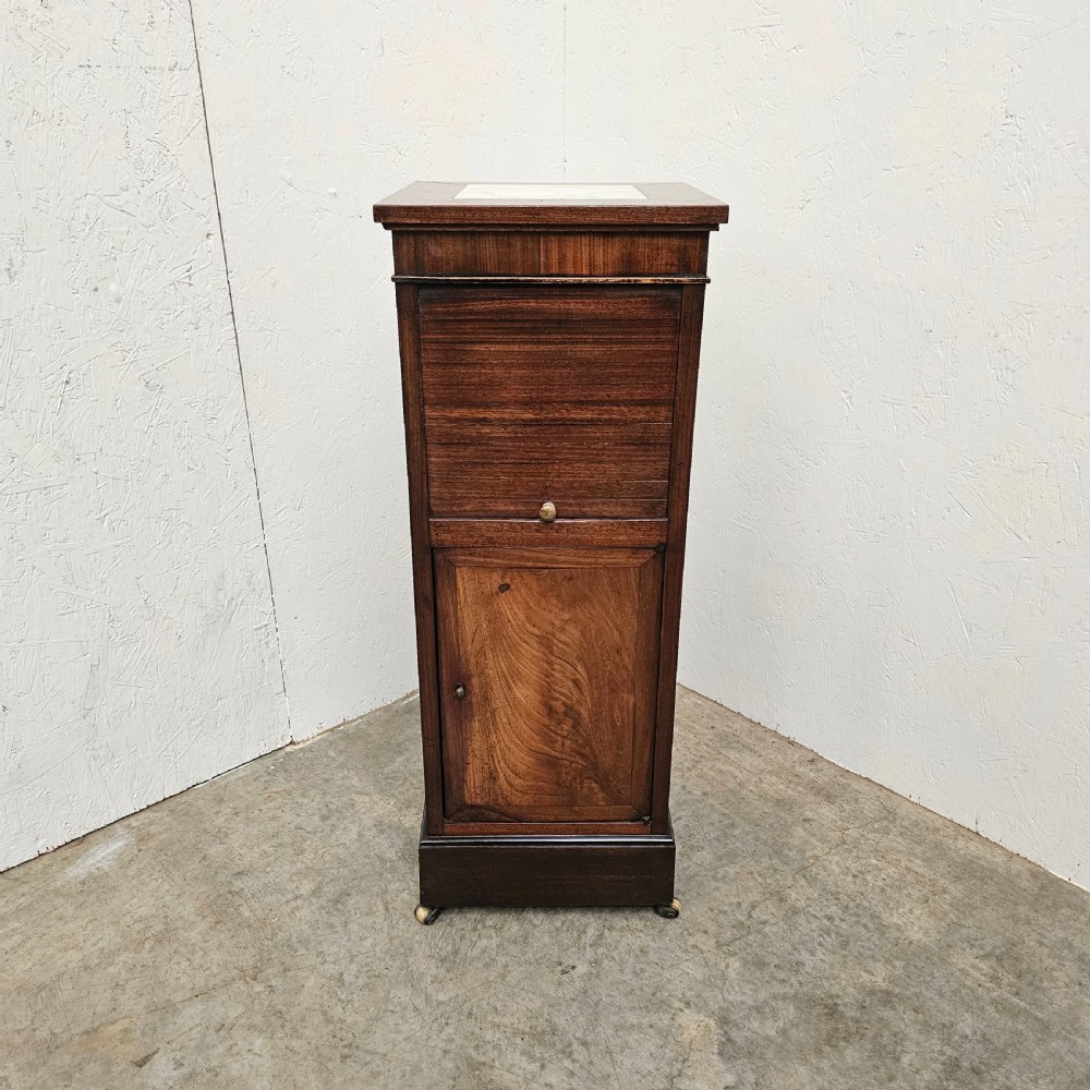 A tall, narrow 19th-century French mahogany nightstand featuring an inset marble top, a sliding tambour door section, and a lower single cupboard door.