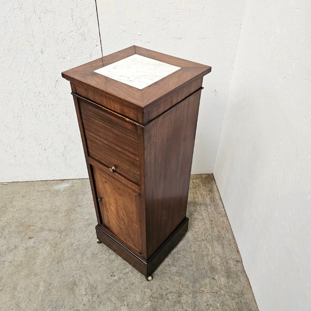 A tall, narrow 19th-century French mahogany nightstand featuring an inset marble top, a sliding tambour door section, and a lower single cupboard door. View III