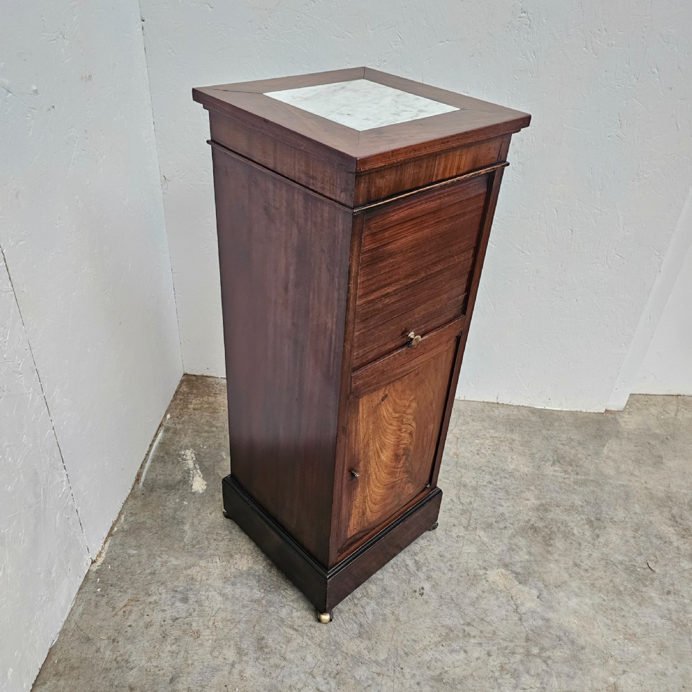 A tall, narrow 19th-century French mahogany nightstand featuring an inset marble top, a sliding tambour door section, and a lower single cupboard door. View IV