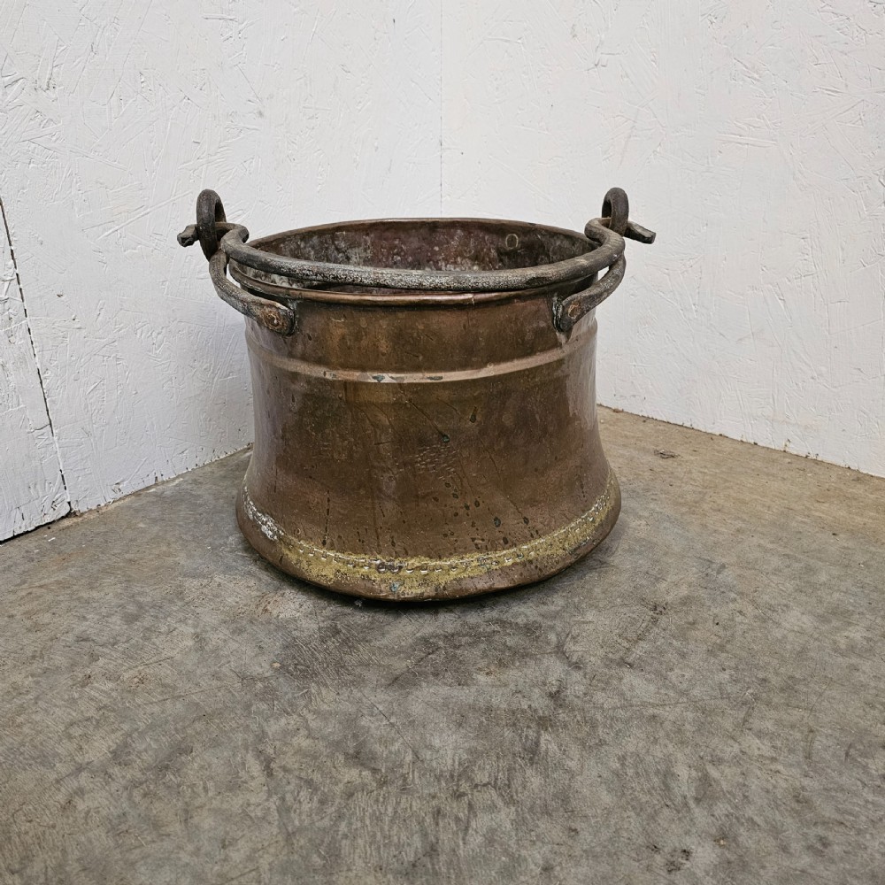 An antique French copper cauldron featuring a tapered body, rolled rim, and twin wrought-iron loop handles. View II