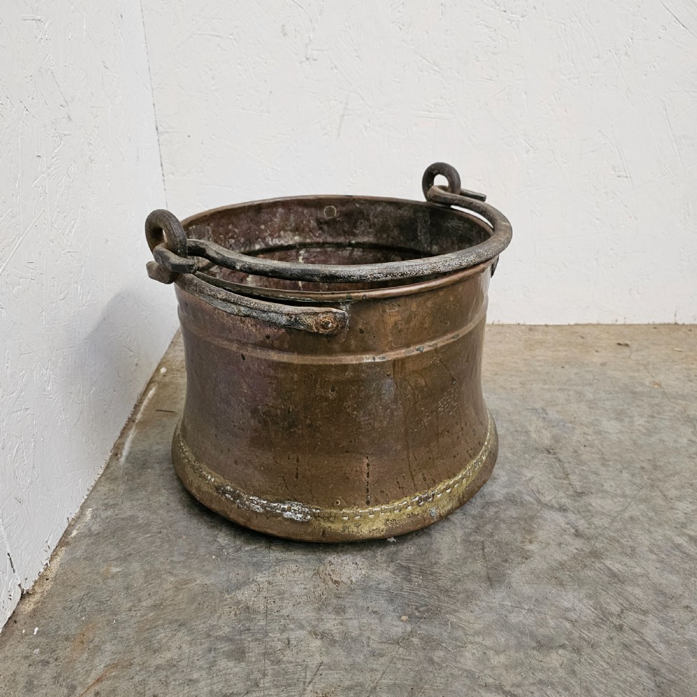 An antique French copper cauldron featuring a tapered body, rolled rim, and twin wrought-iron loop handles. View III