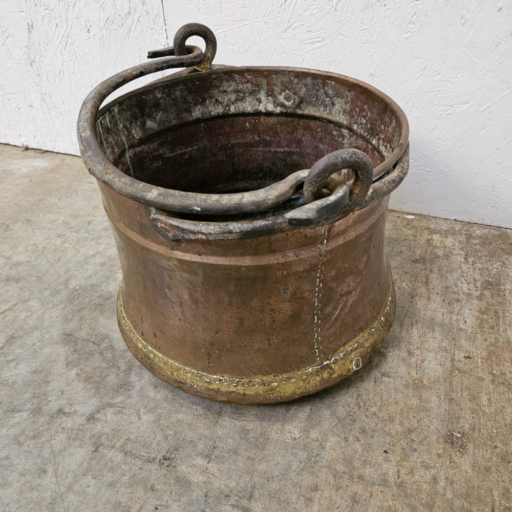 An antique French copper cauldron featuring a tapered body, rolled rim, and twin wrought-iron loop handles. View IV
