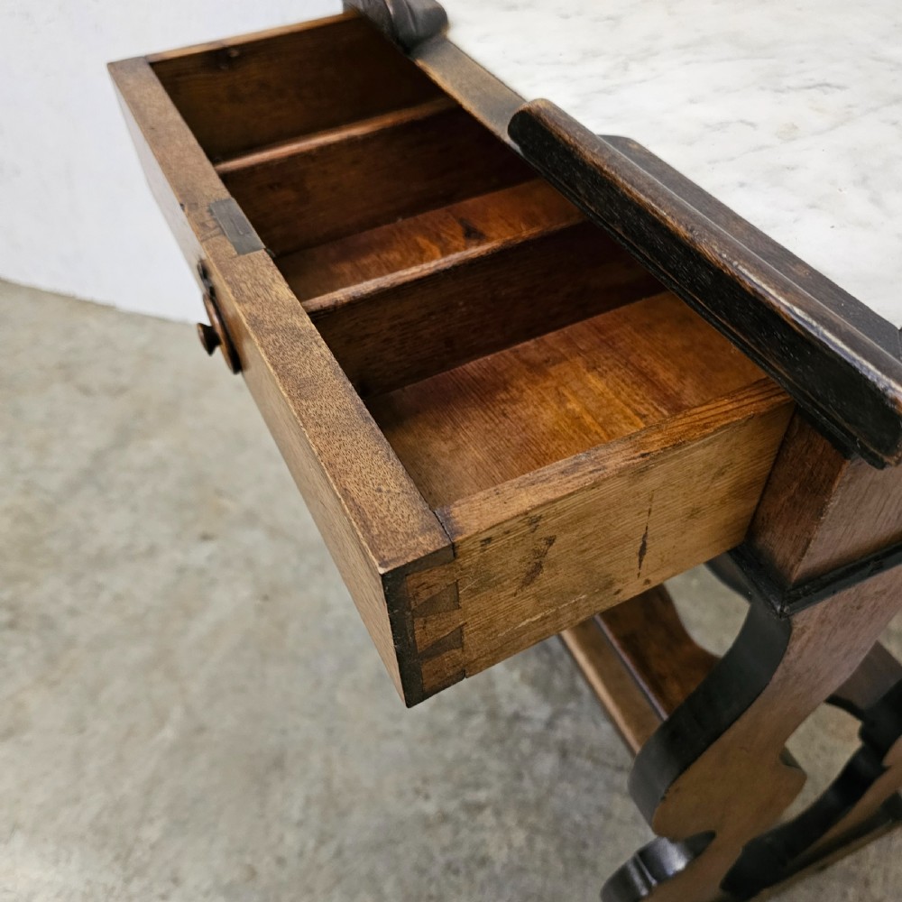 A French 19th-century walnut and ebonised stand featuring an inset marble top, a single frieze drawer, shaped supports, and a lower shelf. View VI