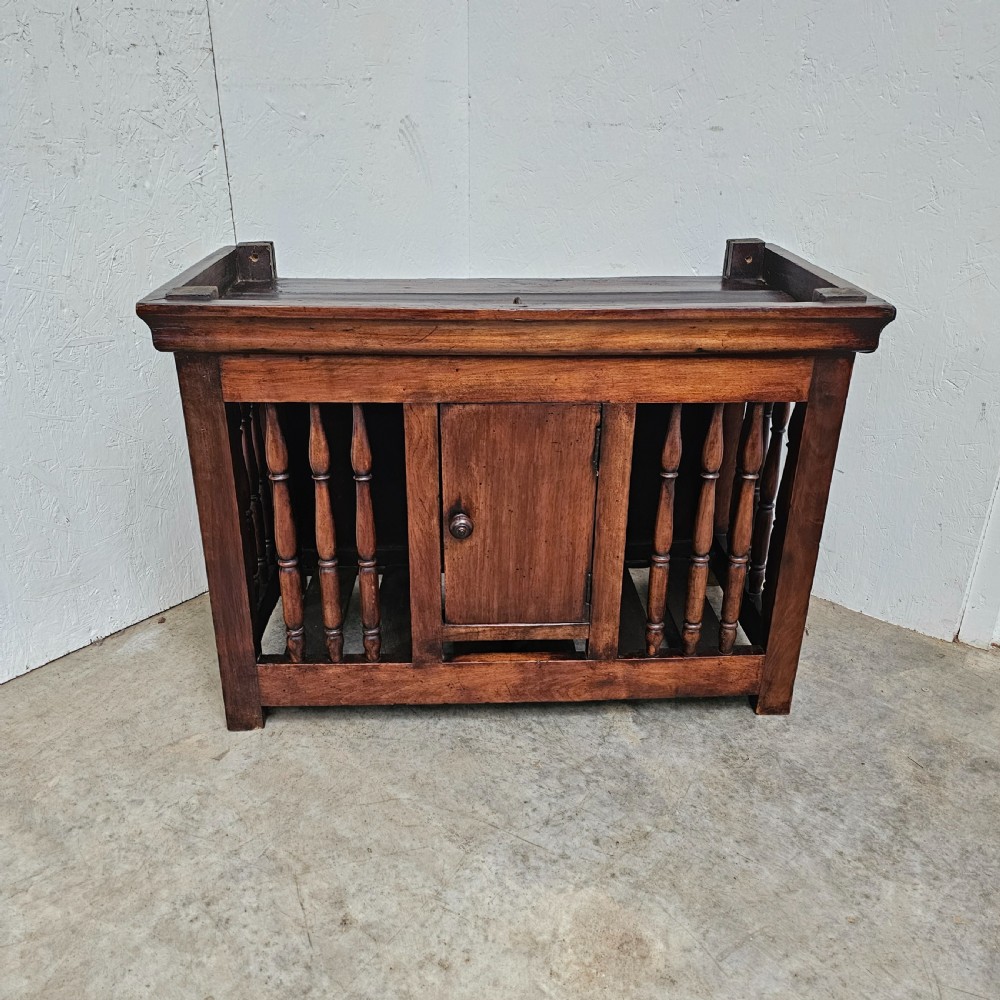 A 19th-century French provincial walnut panetiere with turned spindle sides, a central solid door, and a rich dark finish.
