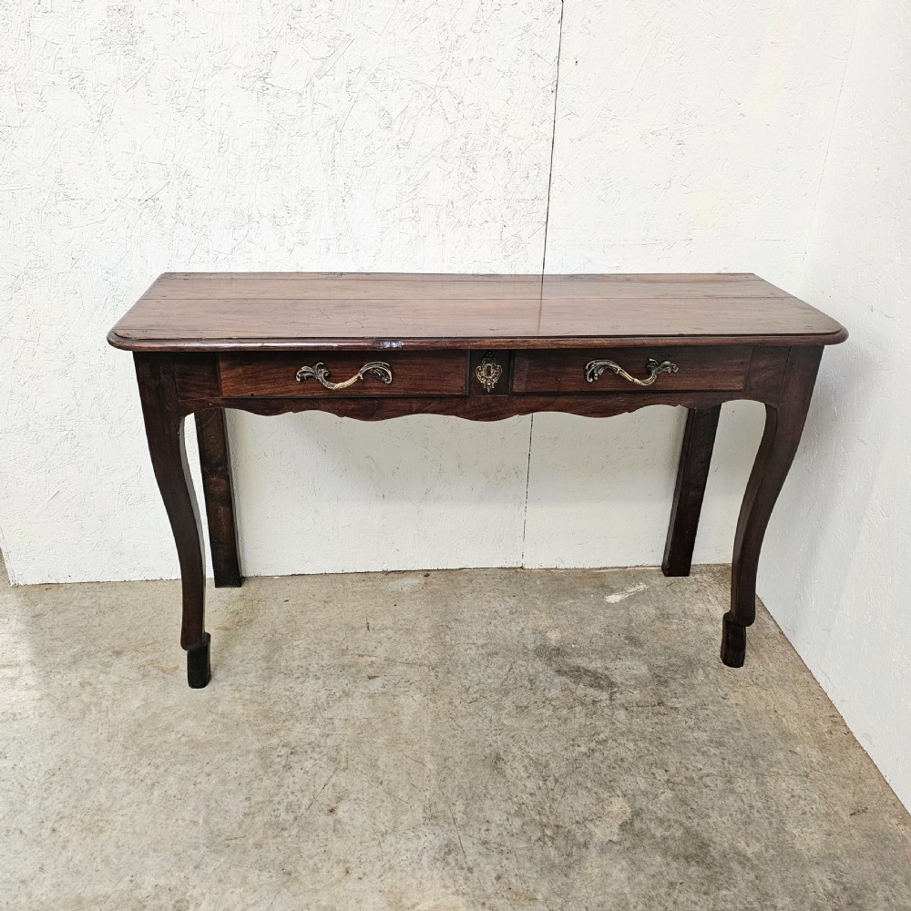 A French cherrywood console table featuring twin front drawers with decorative brass handles, a shaped apron, and front cabriole legs.