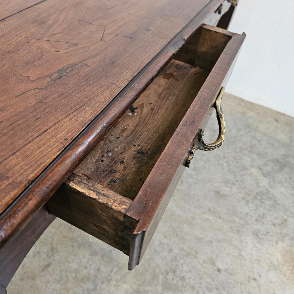 A French cherrywood console table featuring twin front drawers with decorative brass handles, a shaped apron, and front cabriole legs. View III