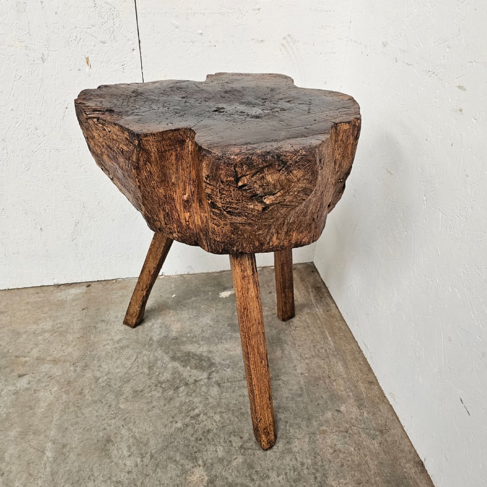A rustic French oak game block made from a thick tree trunk section set upon three splayed wooden legs. View III
