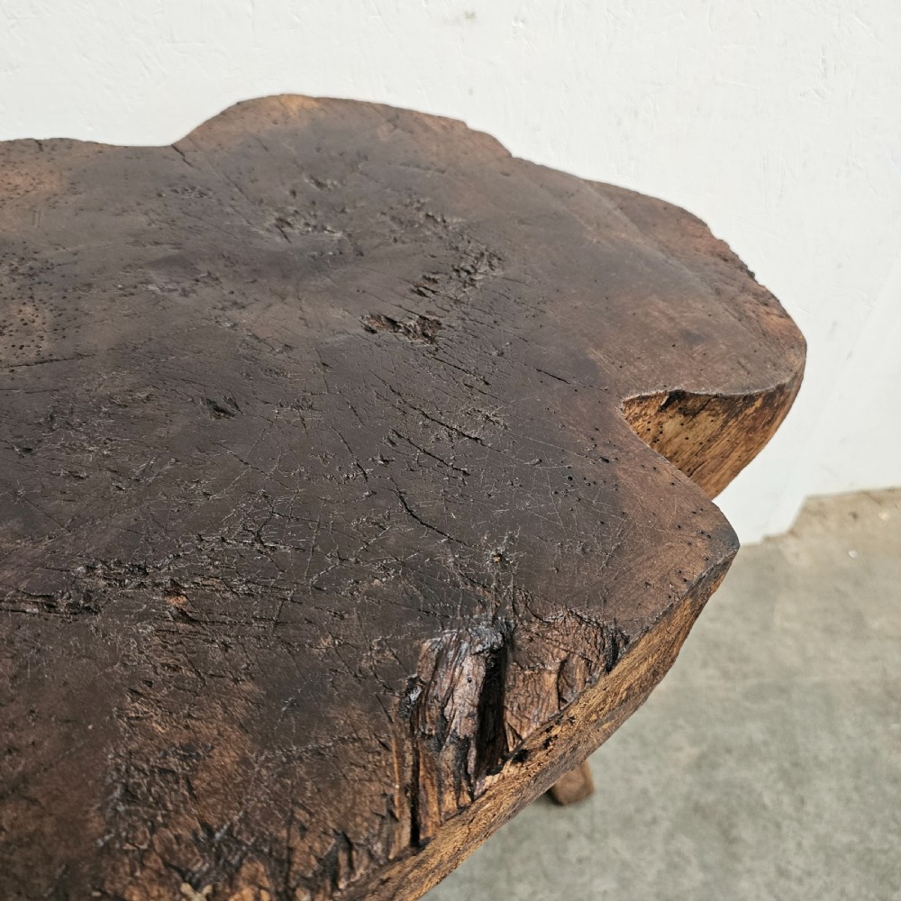 A rustic French oak game block made from a thick tree trunk section set upon three splayed wooden legs. View V