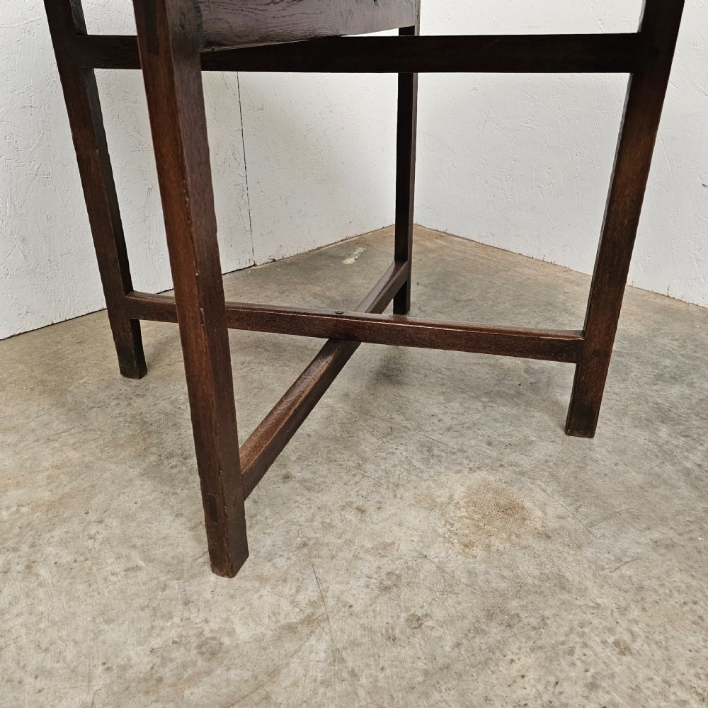An antique dark oak French folding vineyard table with a circular planked tilt top and a wooden cross-trestle base. View VI