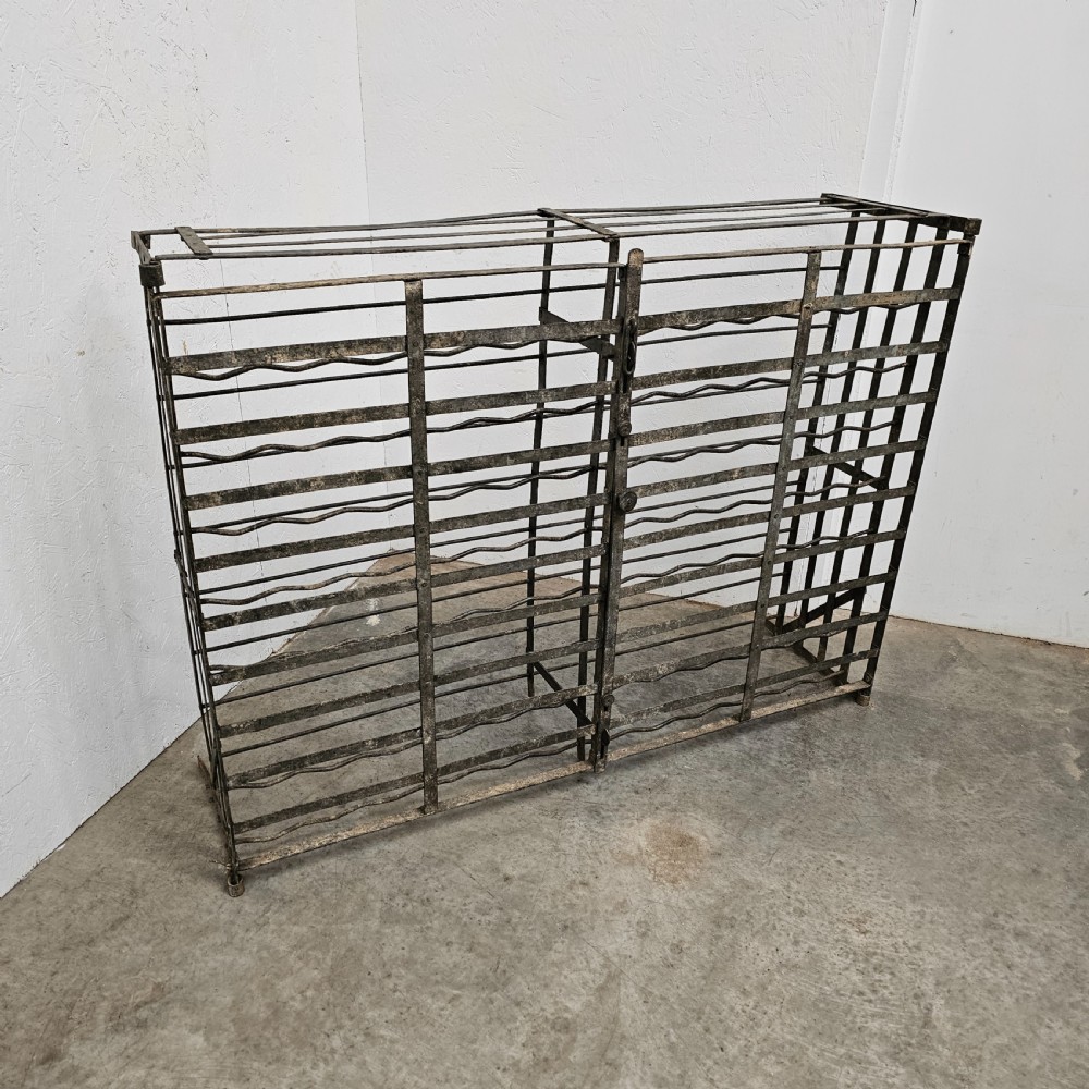 A large French dark iron lockable wine cage with double doors and horizontal bottle slots designed to hold 96 bottles.
