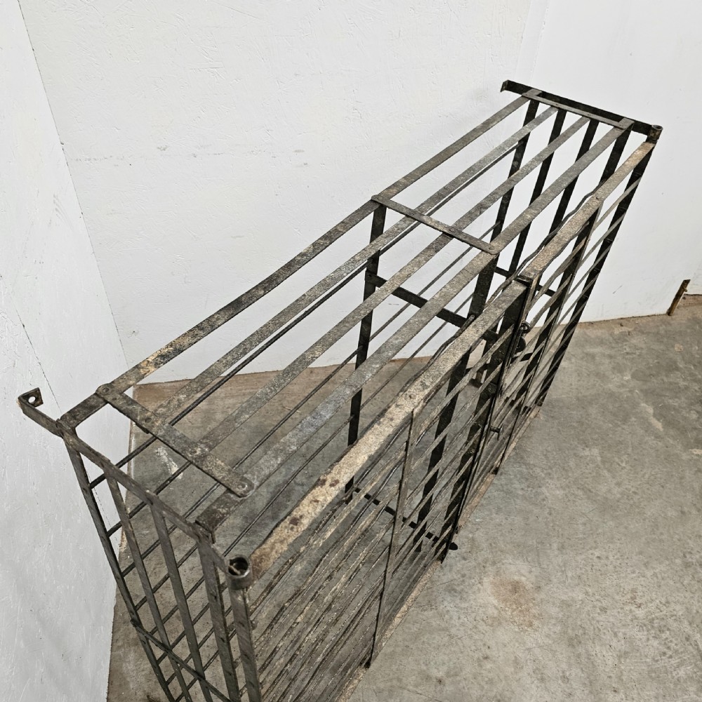 A large French dark iron lockable wine cage with double doors and horizontal bottle slots designed to hold 96 bottles. View II